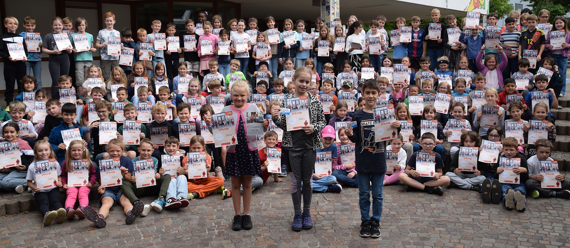 Foto von Kindern mit Urkunde, vorne die 3 Kinder, die einen Preis gewonnen haben